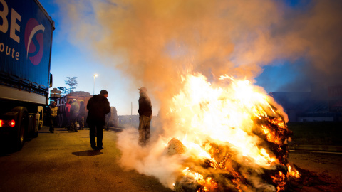 Los manifestantes usan tractores y queman neumáticos cerca de la autopista RN 165 para bloquear el acceso por carretera a Vannes, al oeste de Francia, el 15 de febrero de 2016, durante una protesta contra la caída de los precios de los prod