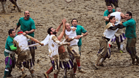 Varios hombres juegan al 'Calcio Fiorentino', una forma primitiva de fútbol que se jugaba originalmente por la aristocracia, en la plaza Santa Croce de Florencia, Italia. EFE/Maurizio Degl' Innocenti