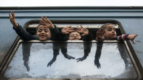 Niños estiran sus brazos mientras esperan a otros refugiados en un tren con destino a Serbia desde la frontera entre Macedonia y Grecia cerca de Gevgelija. Robert ATANASOVSKI/AFP