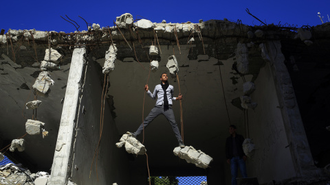 Palestinos juegan en las ruinas de un edificio que fue destruido en 2014  en Gaza. MOHAMMED ABED/AFP