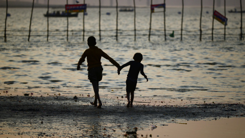 Niños indios de pie en la orilla del Sangam en Allahabad. AFP PHOTO/SANJAY Kanojia