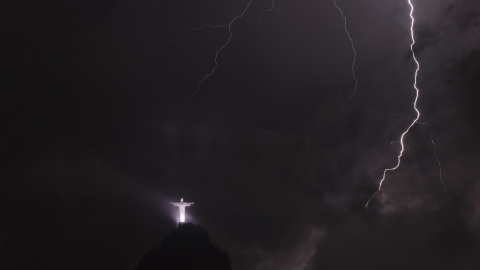 Fotografía de un rayo frente a la imagen del Cristo Redentor durante una tormenta anoche en la ciudad de Río de Janeiro (Brasil). EFE/Marcelo Sayão