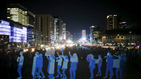 Proyectan la imagen de personas marchando durante una manifestación de estilo holograma organizado por el grupo de derechos humanos Amnistía Internacional para exigir la libertad de reunión en el centro de Seúl, Corea del Sur , 24 de febrer