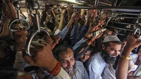 Varios trabajadores viajan hacinados en un tren en la estación de Bombay, India. EFE/Divyakant Solanki