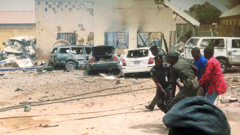 Los miembros de las fuerzas de seguridad llevan un cadáver en el sitio de una explosión que afectó a un cuartel de la policía en la ciudad de Yola, Nigeria, 25 de febrero de 2016.  REUTERS / Stringer