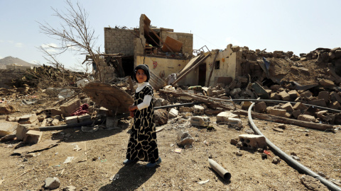 Una niña camina junto a su casa destruida en un ataque aéreo de la coalición liderada por Arabia Saudí en Saná, Yemen. EFE/Yahya Arhab