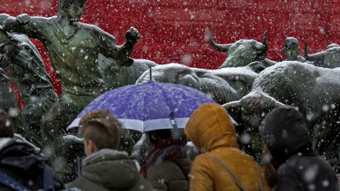 Un grupo de jóvenes camina por una calle de Pamplona donde nieva intensamente desde primeras horas de la tarde. EFe/Villar López