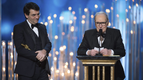 El maestro italiano Ennio Morricone (d) recoge su Óscar a la mejor banda sonora por "The Hateful Eight" (Los Odiosos Ocho) durante la 88ª edición de la ceremonia de los Óscar celebrada la noche de ayer, 28 de febrero de 2016, en el Teatro D