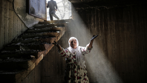 Una mujer reacciona al caminar entre las ruinas de los edificios dañados como consecuencia de los intensos combates entre las tropas gubernamentales y los combatientes kurdos, el 2 de marzo de 2016 en el sudeste de la ciudad kurda de Turquí