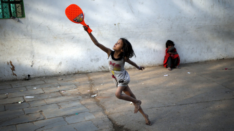 Un niño juega con una raqueta de bádminton de plástico en el casco antiguo de Delhi, India. REUTERS/Anindito Mukherjee