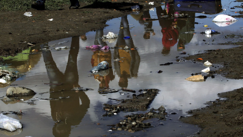 Un grupo de refugiados camina en el interior del campamento de refugiados de Idomeni, al norte de Grecia. EFE/Simela Pantzartzi