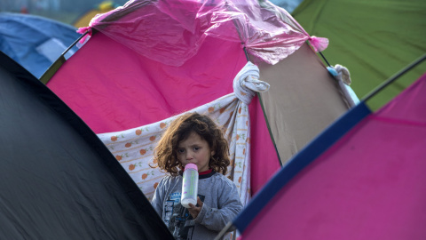 Una niña pequeña espera a poder entrar en Macedonia en un campamento montado junto a la frontera cerca de Idoemeni, norte de Grecia.- EFE