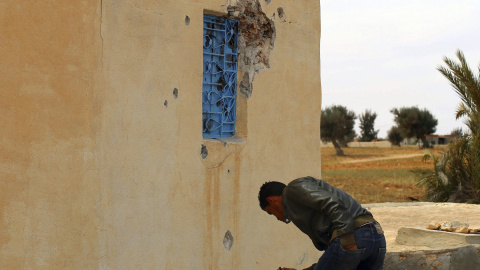 Un hombre observa una casa acribillada a balazos durante los disturbios entre las fuerzas de seguridad tunecinas y los militantes cerca de la frontera con Libia en Ben Guerdan, Túnez. EFE/Stringer