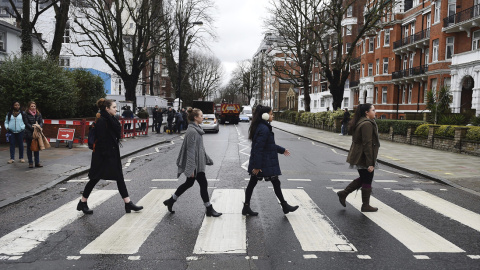 Seguidoras de los Beatles cruzan el famoso paso de cebra junto a los estudios Abbey Road en Londres, el día de la muerte de George Martin, 'arquitecto' del éxito musical de la legendaria banda musical "The Beatles" y considerado como el 'qu