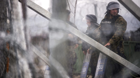 Agentes de policía montan guardia junto a un alambre de púas cerca de Gevgelija, en la frontera Grecia y Macedonia. EFE/Zoltan Balogh