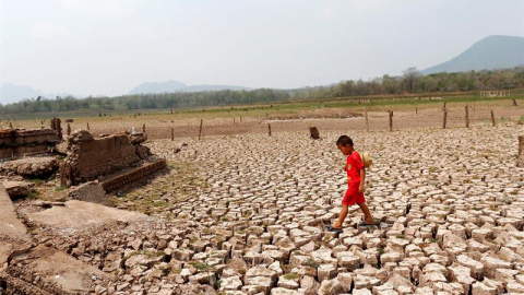 Un niño camina entre las ruinas de una aldea en una zona seca del embalse de Mae Chang en la provincia de Lampang al norte de Tailandia. EFE/Rungroj Yongrit