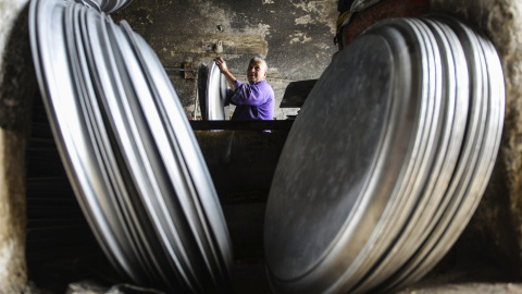 Un operario trabaja en el proceso de secado de piezas de menaje de cocina de aluminio en un taller de Mit Ghamr, Dakahlia, a 80 km al noreste de El Cairo (Egipto)./EFE/Mohammed Hossam