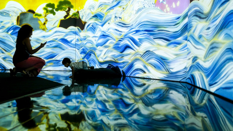 Una visitante fotografía a su hijo mientras interactua con la obra de luces llamada 'Mar de 100 años' que forma parte de una instalación mostrada en la feria 'Future World' en el Museo de las Artes y las Ciencias de Singapur. EFE/Wallace Wo