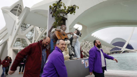 Un grupo de falleros se llevan la figura de un labrador valenciano tocando la guitarra, acompañado de un niño y un perro, que ha sido el grupo que ha conseguido el indulto en las Fallas 2016, obra del artista Manuel Algarra para la falla Al