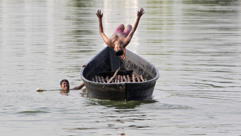 Un niño salta de un barco en un lago en Agartala, India. REUTERS/Jayanta Dey