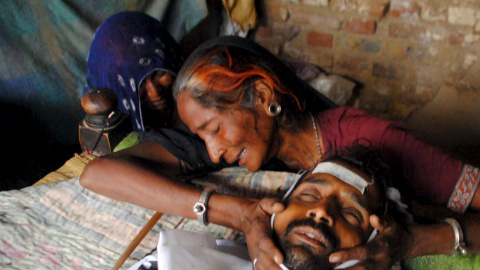 Una mujer llora la muerte de un hombre que murió tras consumir alcohol de contrabando en Pakistán. REUTERS/Akram Shahid