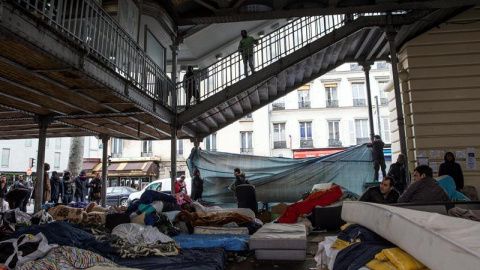 Migrantes procedentes de Afganistán, Sudán, y Eritrea montan un campamento temporal debajo de la estación de metro Stalingrad en París, Francia. EFE/Etienne