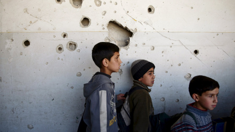 Estudiantes permanecen en su escuela dañada en una zona controlada por los rebeldes en Damasco. REUTERS/Bassam Khabieh
