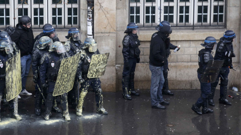 La policía antidisturbios francesa protegerse detrás de escudos durante una manifestación de estudiantes de instituto y universitarios franceses en contra de la propuesta de la legislación laboral francés en París. REUTERS