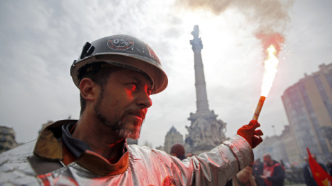 Un minero vestido con un traje protector sujeta una bengala en una manifestación en contra de la reforma laboral francés en Marsella, Francia. REUTERS