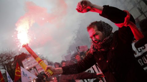 Universitarios franceses asisten con bengalas a una manifestación en París en contra de reforma laboral propuesta por Hollande. REUTERS
