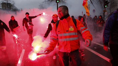 Varios trabajadores franceses del ferrocarril llevan bengalas en una manifestación en contra de la reforma laboral en París, Francia./ REUTERS / Benoit Tessier