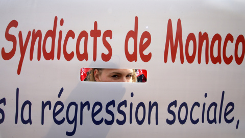 Un miembro de un sindicato obrero de Monaco mira a través de una pancarta durante una manifestación en contra de la reforma laboral francesa en Niza, Francia. REUTERS / Eric Gaillard