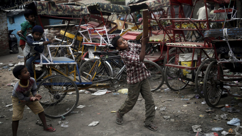 Los niños juegan al críquet frente a los rickshaws estacionados en el casco antiguo de Delhi, India 31 de marzo de 2016. REUTERS / Anindito Mukherjee