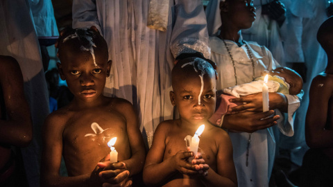 Jóvenes africanos son bautizados durante la celebración de una misa en una iglesia oriental en Kibera, en Nairobi, Kenia. FREDRIK LERNERYD / AFP