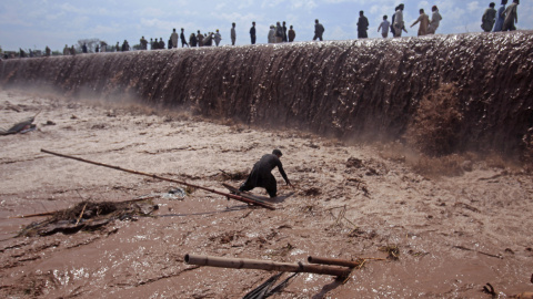 Un comerciante trata de salvar sus pertenencias tras la inundación por las fuertes lluvias en el distrito de Nowshera, en las afueras de Peshawar, Pakistán. REUTERS/Fayaz Aziz