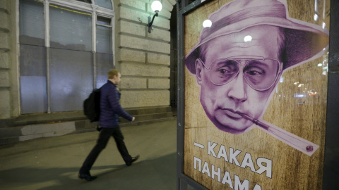 Un hombre pasa junto a un cartel que representa al presidente ruso, Vladimir Putin, junto a las palabras "¿Qué Panamá?" en una parada de autobús en Moscú. REUTERS / Sergei Karpukhin