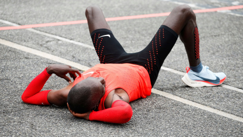 Eliud Kipchoge, tumbado en el suelo tras cruzar la meta del Circuito de Monza (Italia) sin haber logrado bajar el maraton de las dos horas. REUTERS/Alessandro Garofalo