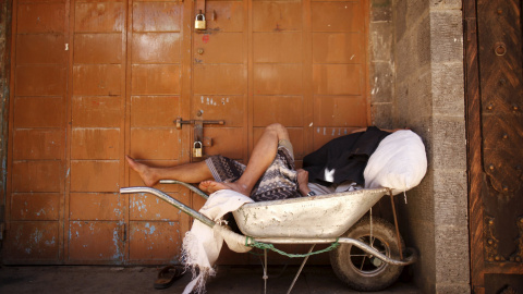 Un hombre duerme en una carretilla fuera de una tienda cerrada en un mercado durante el primer día de un alto el fuego en la capital de Yemen. REUTERS/Khaled Abdullah