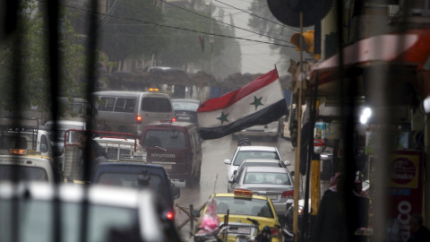Una bandera siria ondea en una abarrotada calle comercial de Qamishli. /REUTERS-Rodi Said