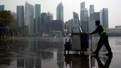 Un barrendero trabaja con el skyline de Singapur de fondo. /REUTERS-Edgar Su