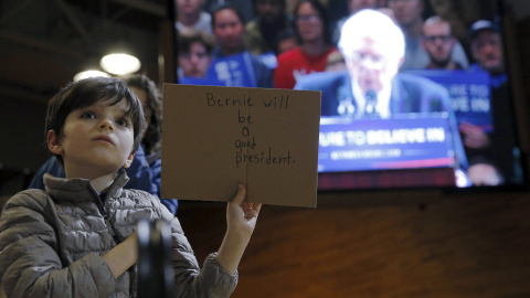 Un niño sostiene un cartel escrito que dice "Bernie será un buen presidente", en referencia al candidato demócrata a la presidencia estadounidense Bernie Sanders, mientras este habla en un acto de campaña en Poughkeepsie, Nueva York. REUTER
