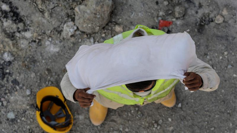 Un trabajador de la construcción usa una toalla pequeña para taparse la cabeza antes de comenzar su jornada laboral, en Kuala Lumpur, Malasia. EFE/Fazry Ismail