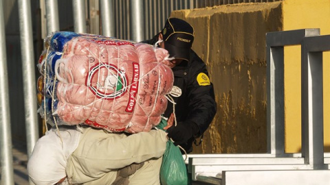 Una mujer porteadora carga con un fardo en el paso habilitado entre Ceuta y Marruecos.- APDHA Una mujer porteadora carga con un fardo en el paso habilitado entre Ceuta y Marruecos.- APDHA