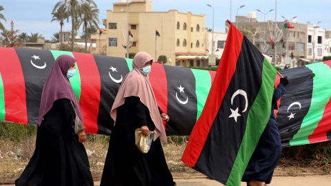Una mujer libia porta una bandera nacional en la capital, Trípoli, el 25 de febrero de 2021. Una mujer libia porta una bandera nacional en la capital, Trípoli, el 25 de febrero de 2021.