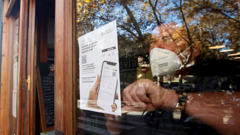 26/11/2021.- El responsable de un bar del barrio de Gracia de Barcelona cuelga un cartel avisando a sus clientes de la necesidad de presentar el certificado de vacunación para entrar en el local. 26/11/2021.- El responsable de un bar del barrio de Gracia de Barcelona cuelga un cartel avisando a sus clientes de la necesidad de presentar el certificado de vacunación para entrar en el local.