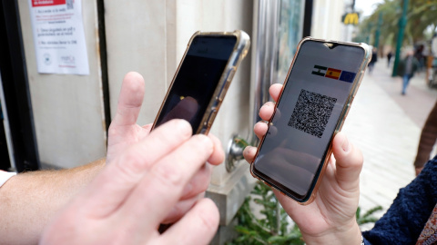 Un camarero solicita el certificado a los clientes en la puerta de un bar durante el primer día de petición de Certificados Covid-19 para la hostelería, a 20 de diciembre de 2021 en Málaga. Un camarero solicita el certificado a los clientes en la puerta de un bar durante el primer día de petición de Certificados Covid-19 para la hostelería, a 20 de diciembre de 2021 en Málaga.