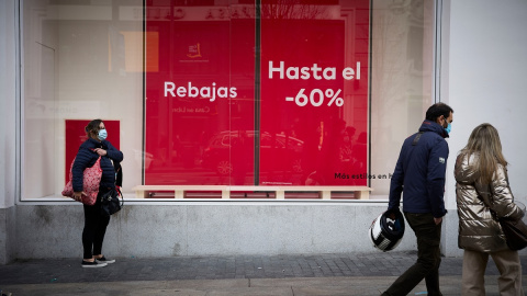 5/1/22-Varias personas pasan delante de un escaparate con cartel de rebajas en una calle comercial del centro de Madrid, a 2 de enero de 2022, en Madrid, (España). 5/1/22-Varias personas pasan delante de un escaparate con cartel de rebajas en una calle comercial del centro de Madrid, a 2 de enero de 2022, en Madrid, (España).