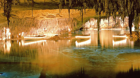 Barcas iluminadas en el lago Martel en el interior de las Cuevas del Drach
