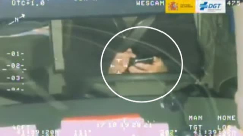 Un conductor juega con un cubo de colores mientras conduce Un conductor juega con un cubo de colores mientras conduce