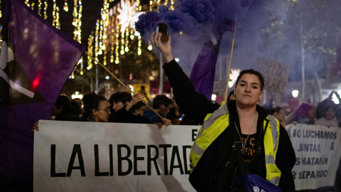 Una mujer con un bote de humo morado, durante una manifestación por el 25N en Barcelona. Una mujer con un bote de humo morado, durante una manifestación por el 25N en Barcelona.